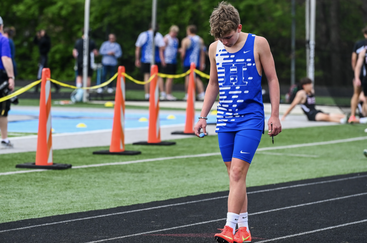 Sam Cleves (9) adjusts his block before starting the 200m dash. 
